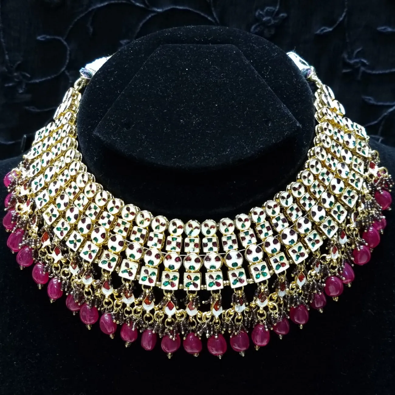 Bridal kundan piece is four layered set with dangling emeralds to match your festive.