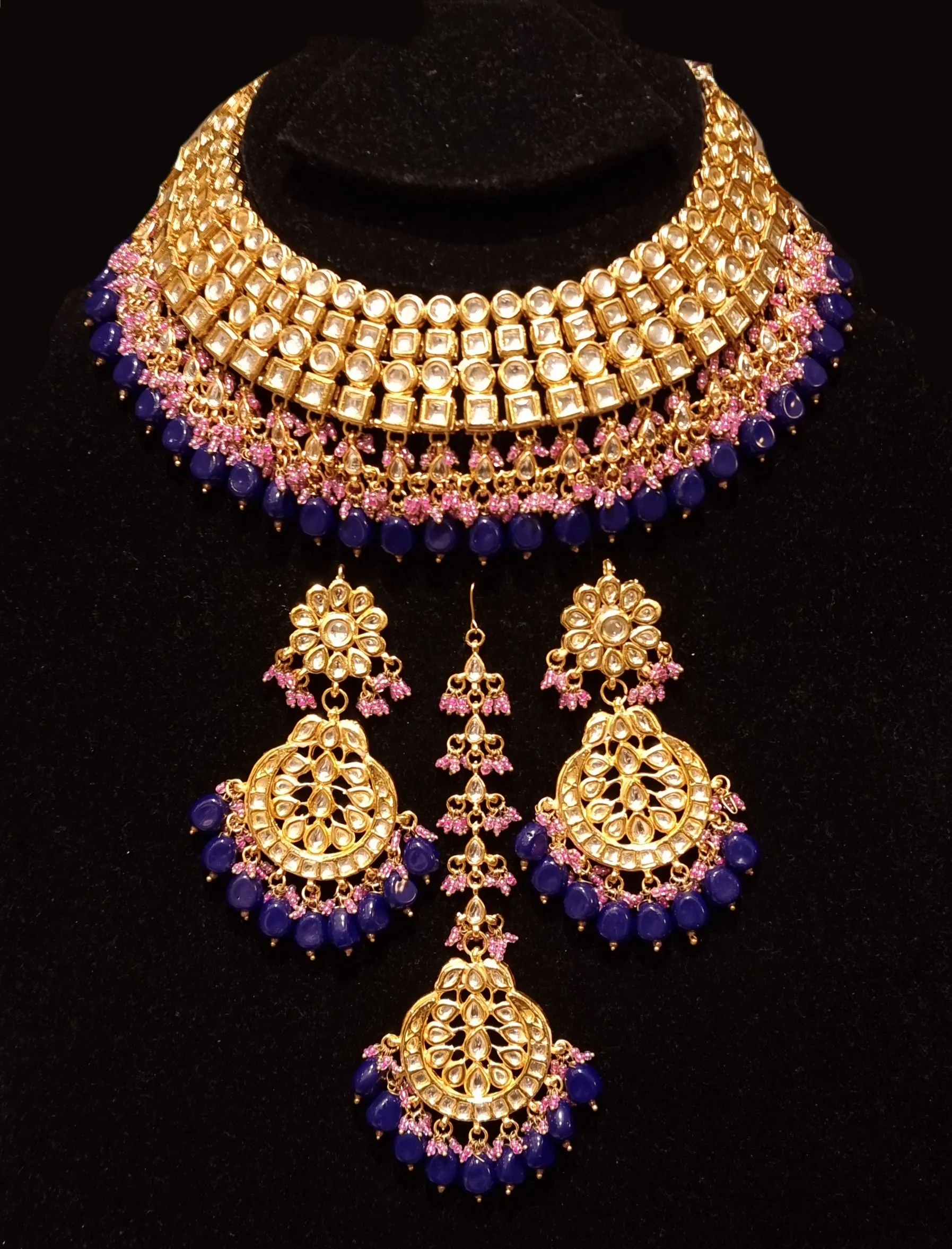 Bridal kundan piece is four layered set with dangling emeralds to match your festive.